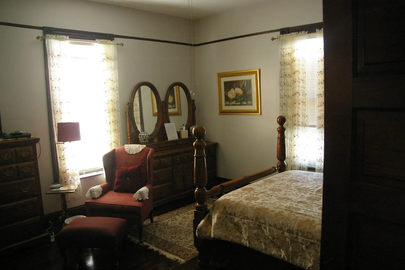 A bedroom with two mirrors and a bed