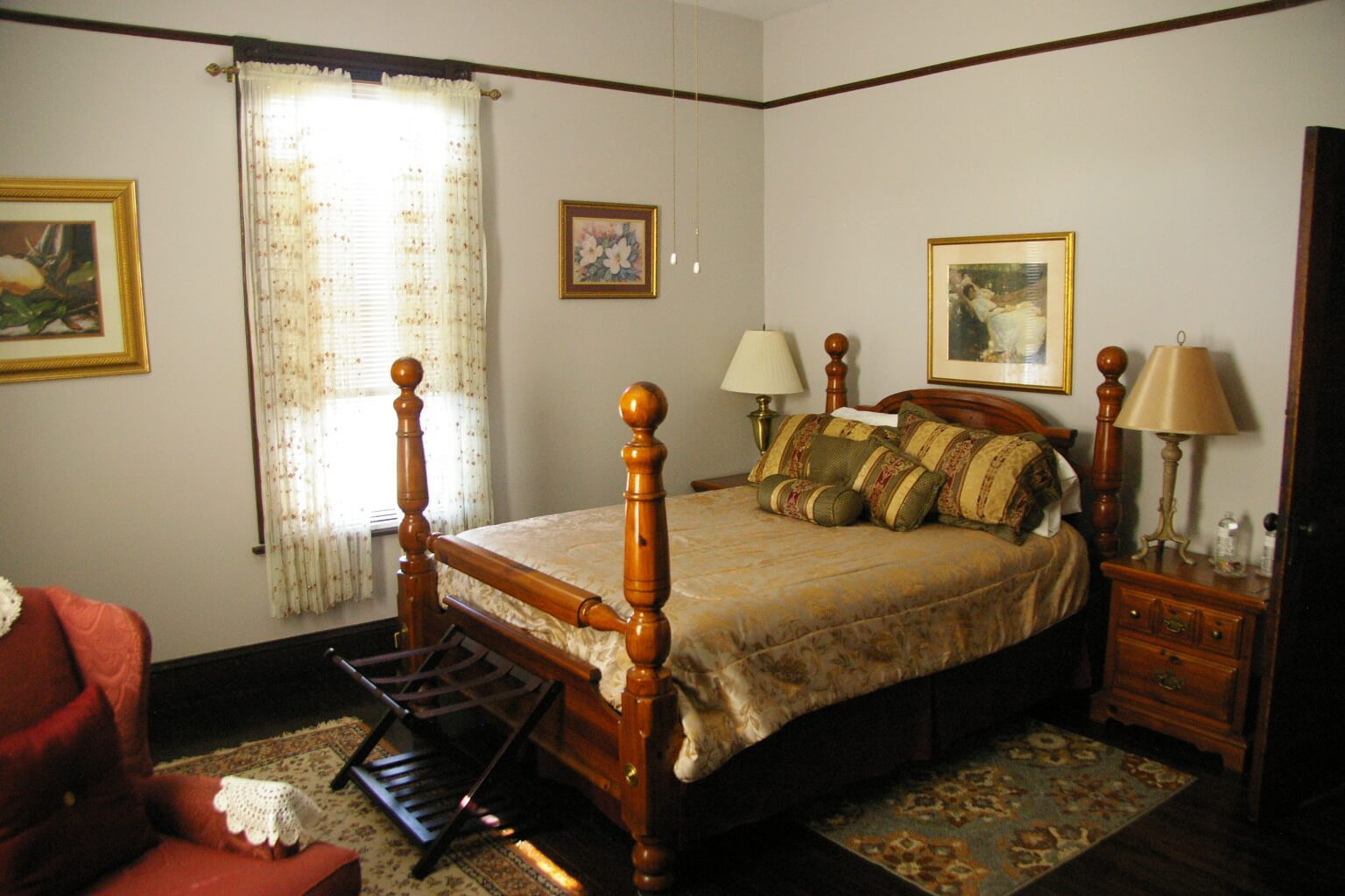 A bedroom with a bed, chair and window.