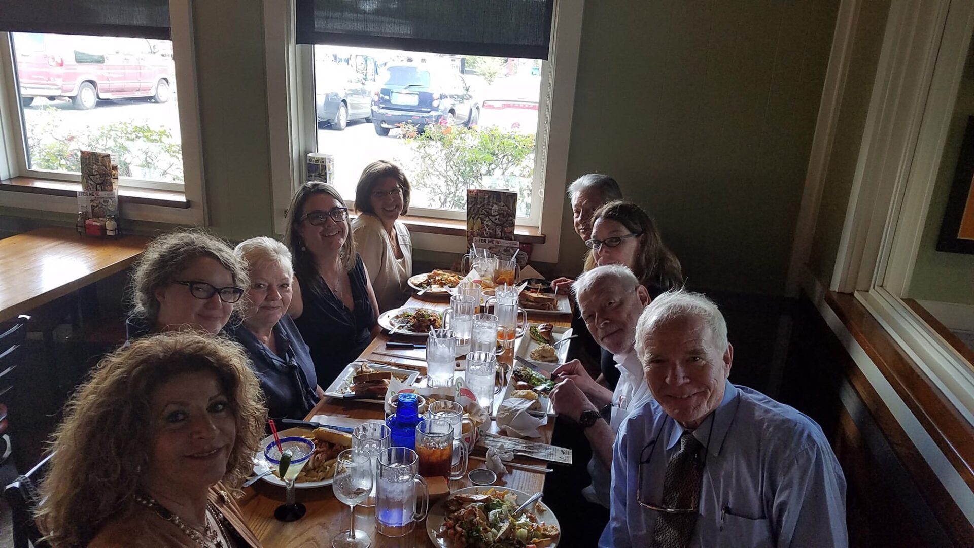 A group of people sitting at a table with plates and glasses.