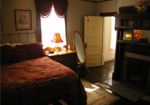 A bedroom with a bed, dresser and mirror.