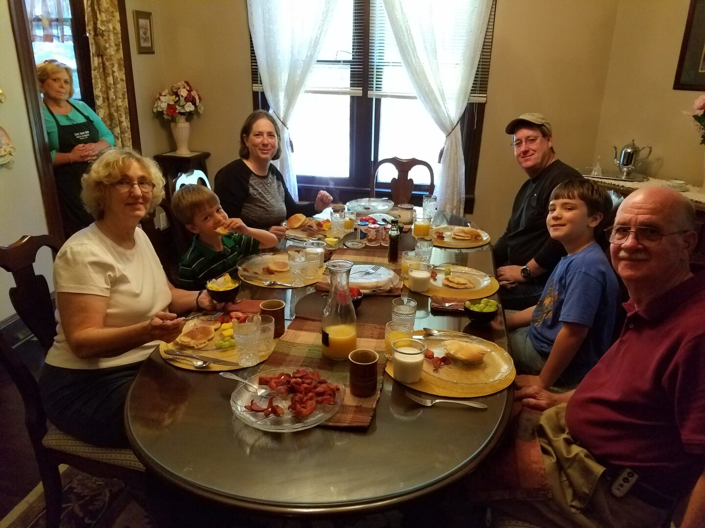 A group of people sitting around a table eating food.