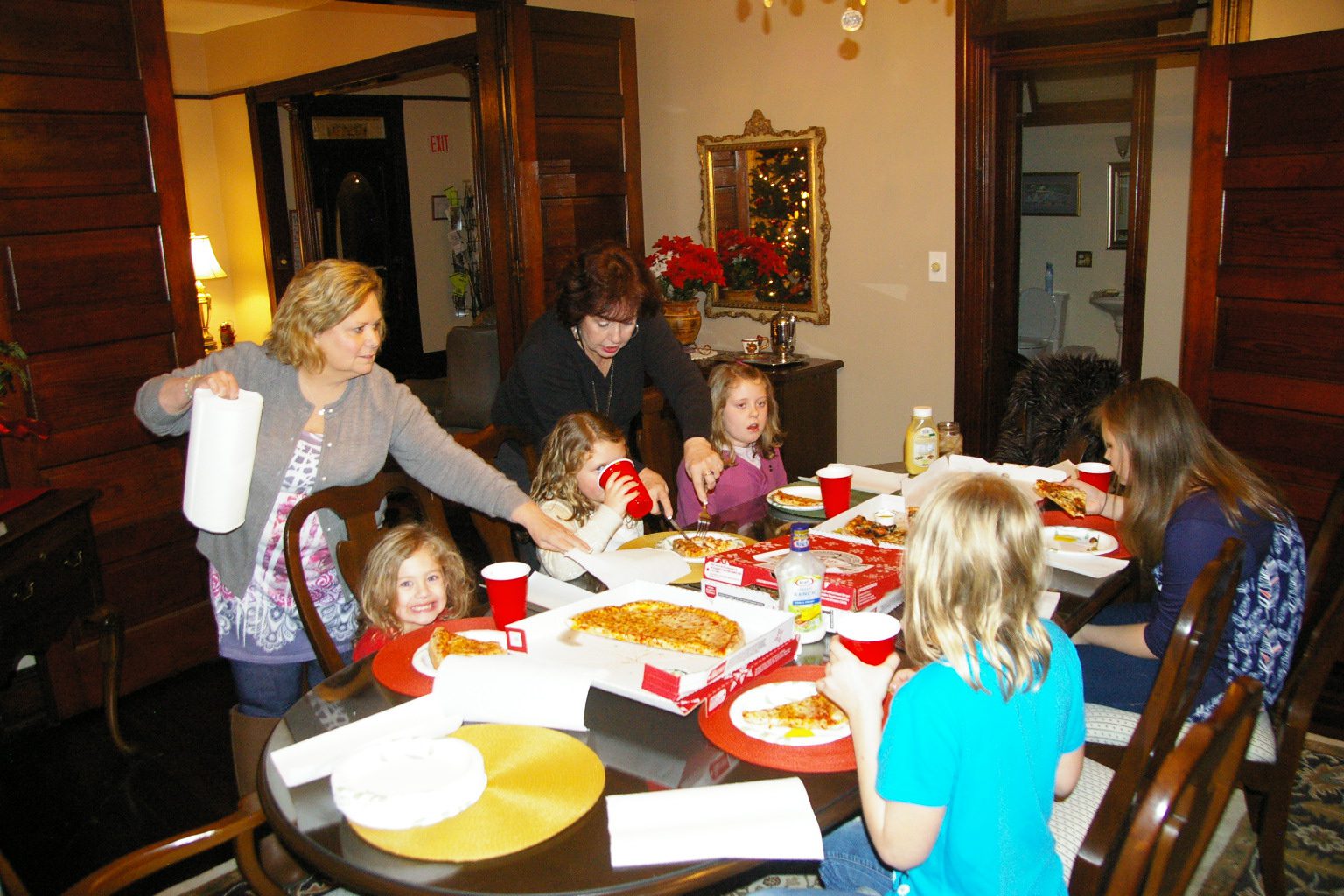 A group of people sitting at a table eating pizza.