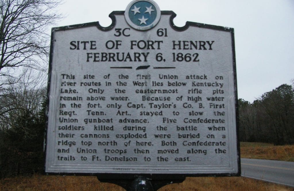 A historical sign is shown on the side of a road.